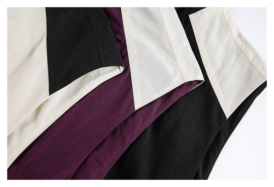 Close-up of overlapping cream, plum, and black jacket hems with contrasting panels and stitched edges.