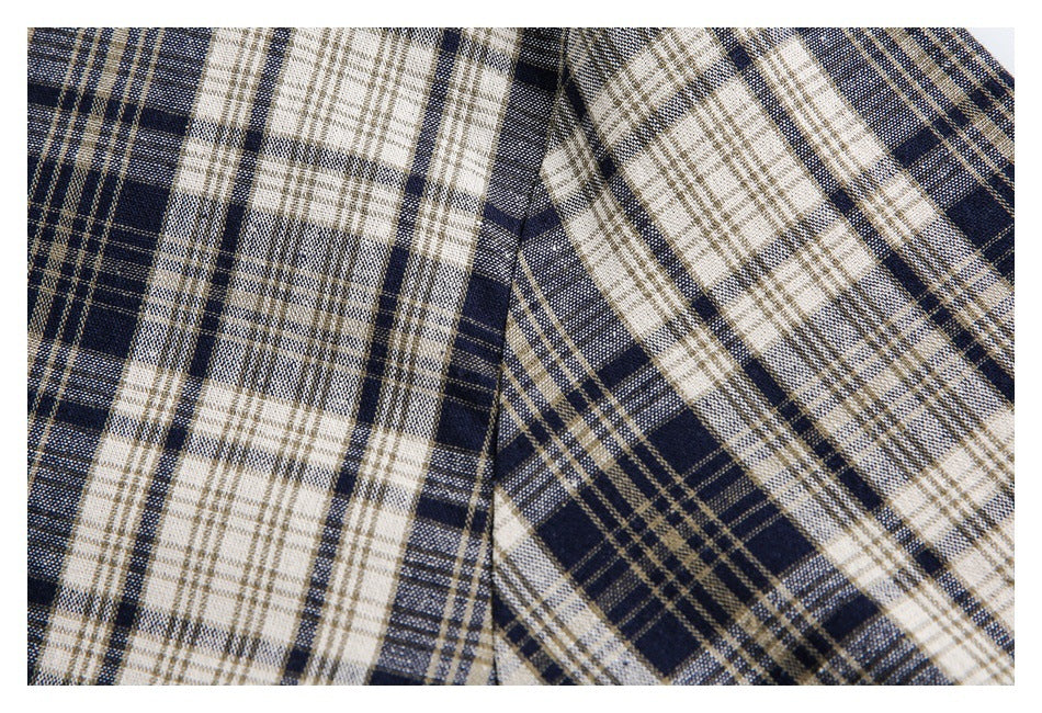 Close-up showing the navy and cream plaid pattern and a garment seam.