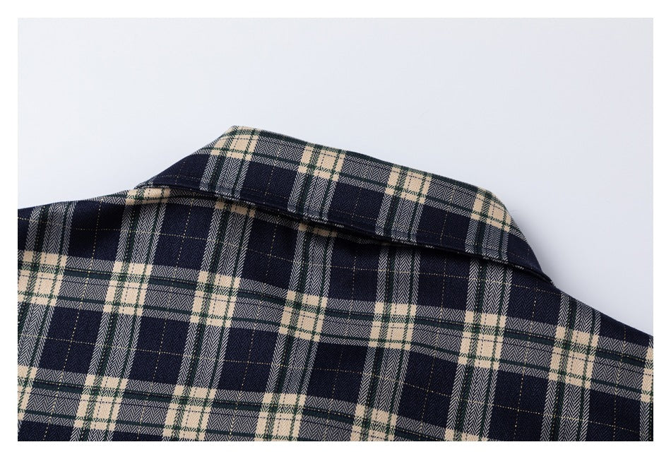 Close-up of the pointed collar on a navy, cream, and green plaid shirt.