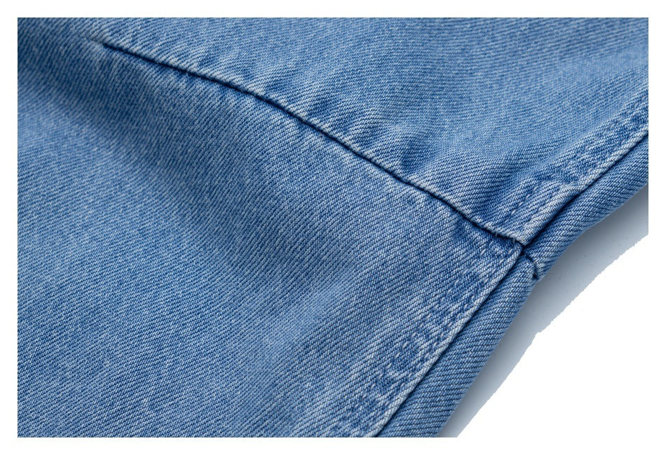 Close-up of light blue jeans showing a curved seam and stitched edge.