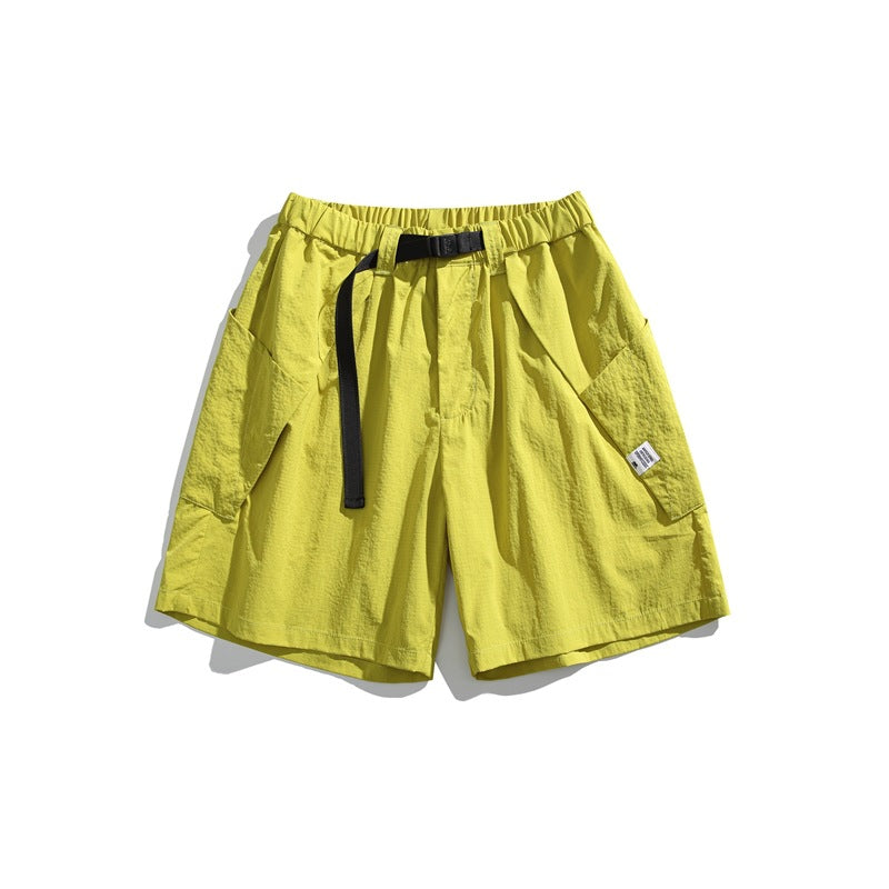 Fluorescent yellow knee-length shorts with black buckle belt and large side patch pockets, flat lay