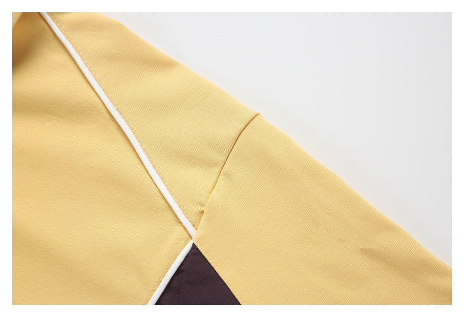 Close-up of a pale yellow sleeve and body with white piping beside a dark contrasting underarm panel.