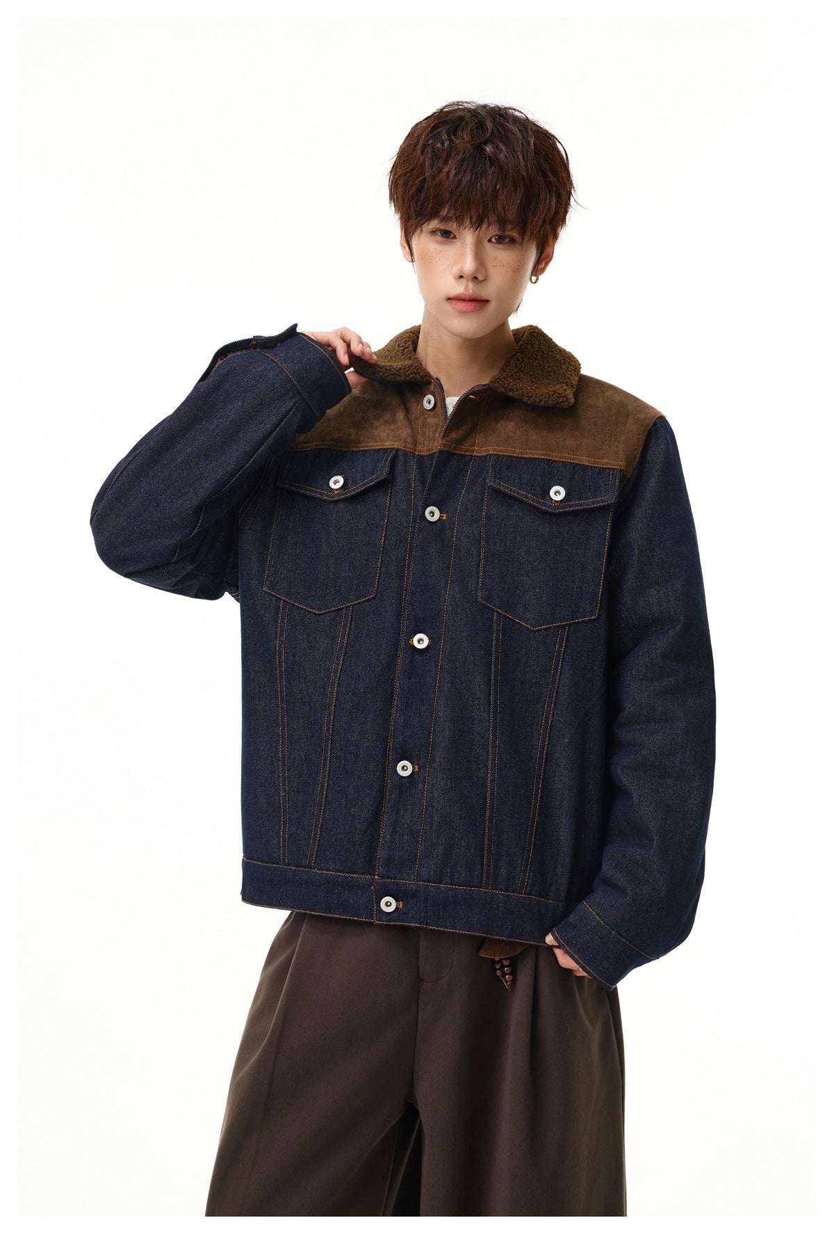 Model wearing a button-front dark denim jacket with brown shoulder panels, sherpa collar, and two chest pockets.