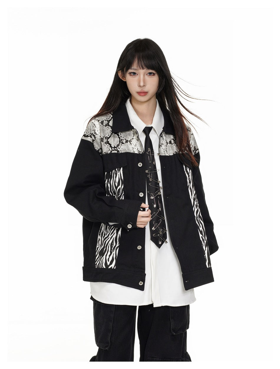 Model in a black jacket with snakeskin and zebra-print panels, shown from the front over a white shirt.