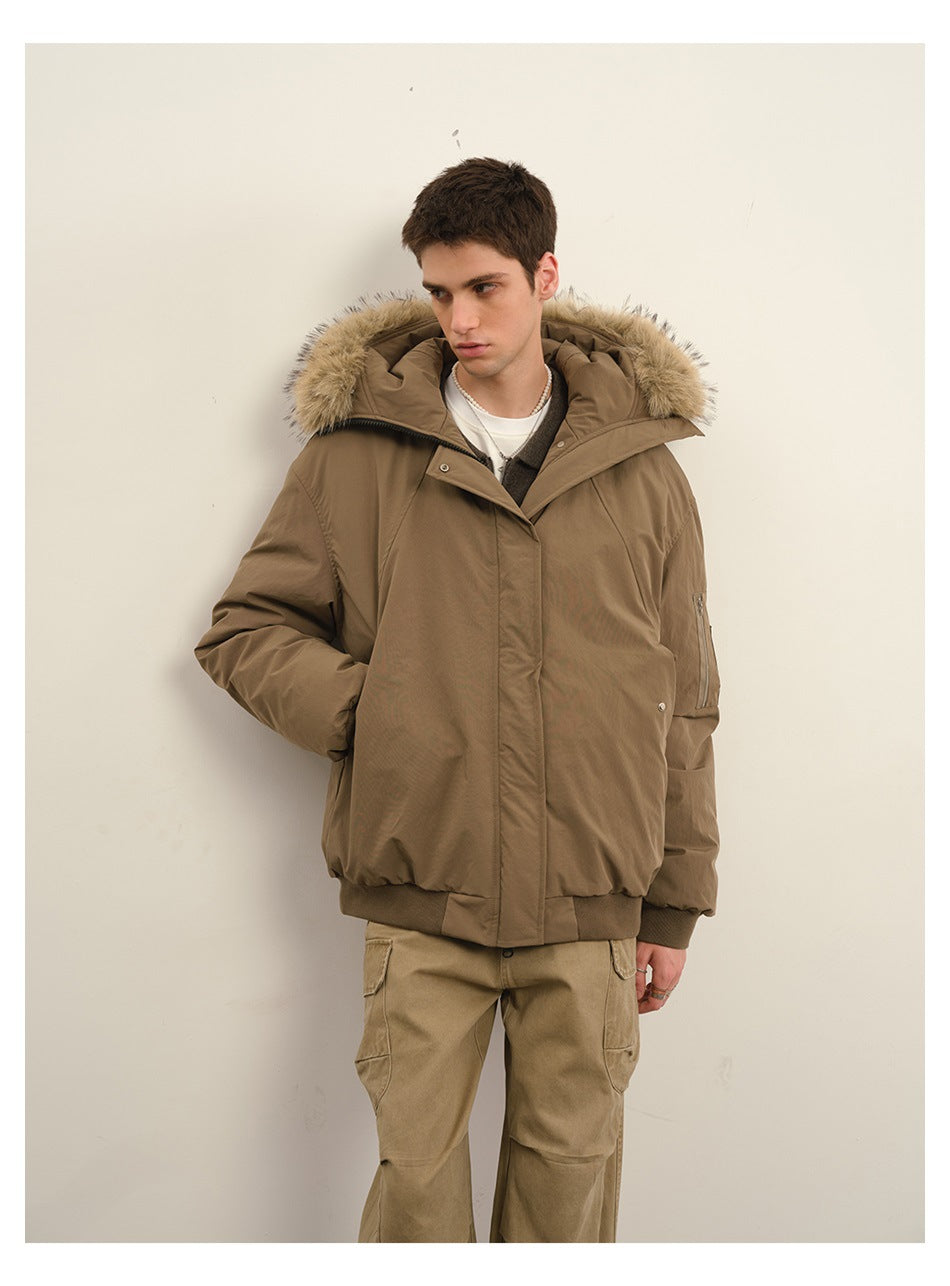 Model wearing a taupe padded jacket with a beige fur-trimmed hood and tan cargo trousers, facing forward.