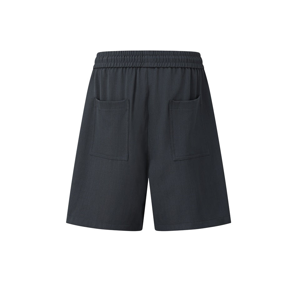 Rear view of dark charcoal shorts with an elastic waistband and two patch pockets.