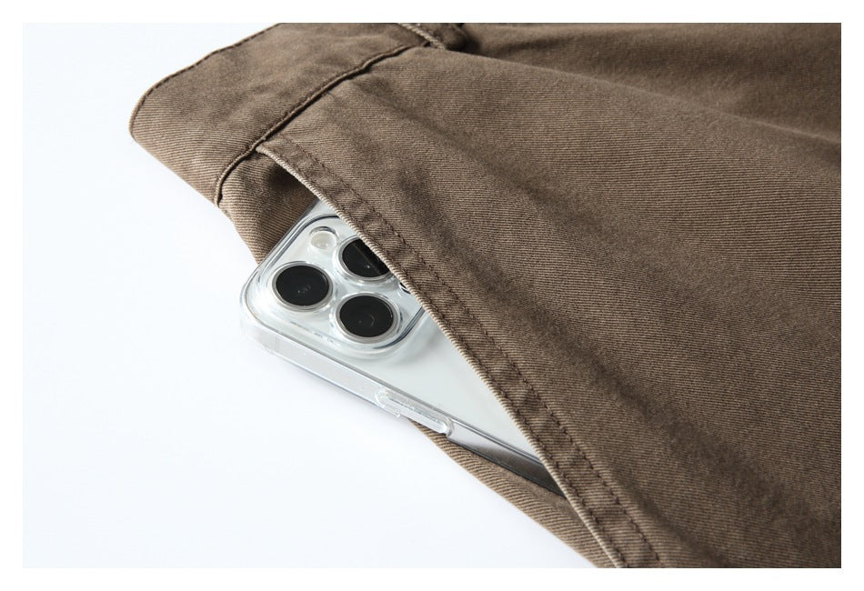 Close-up of a brown trouser pocket holding a smartphone, showing the pocket opening and stitching.