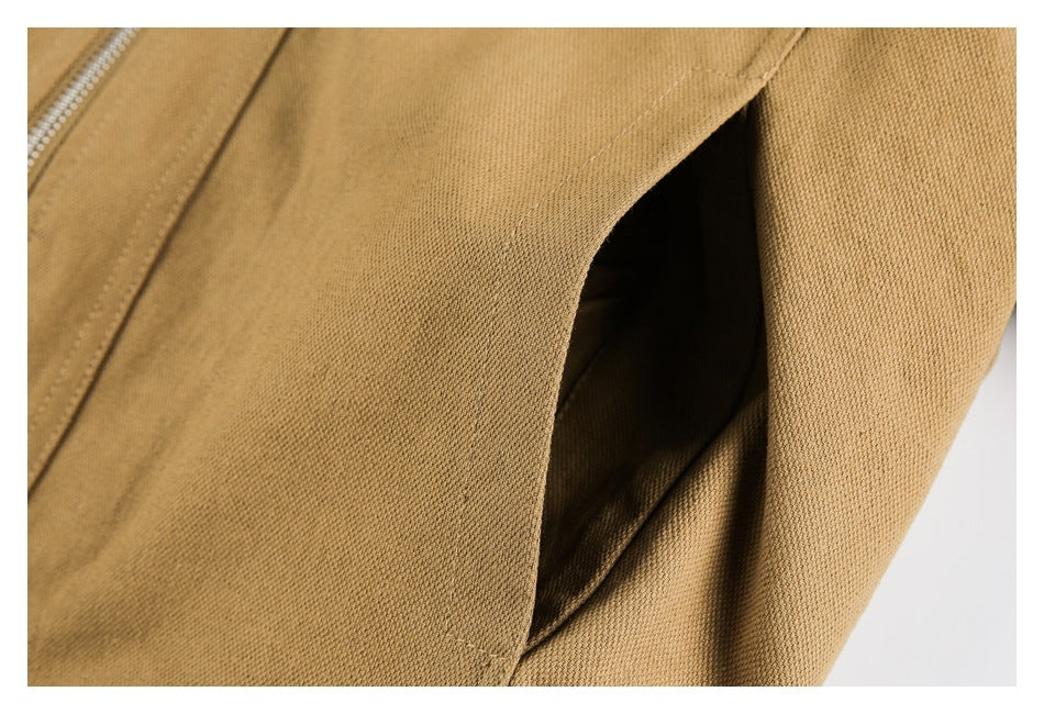 Close-up of tan jacket fabric and a folded seam or opening.
