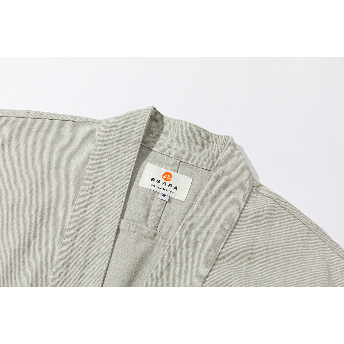 Close-up of a light gray-green jacket's collar and inner neck label.