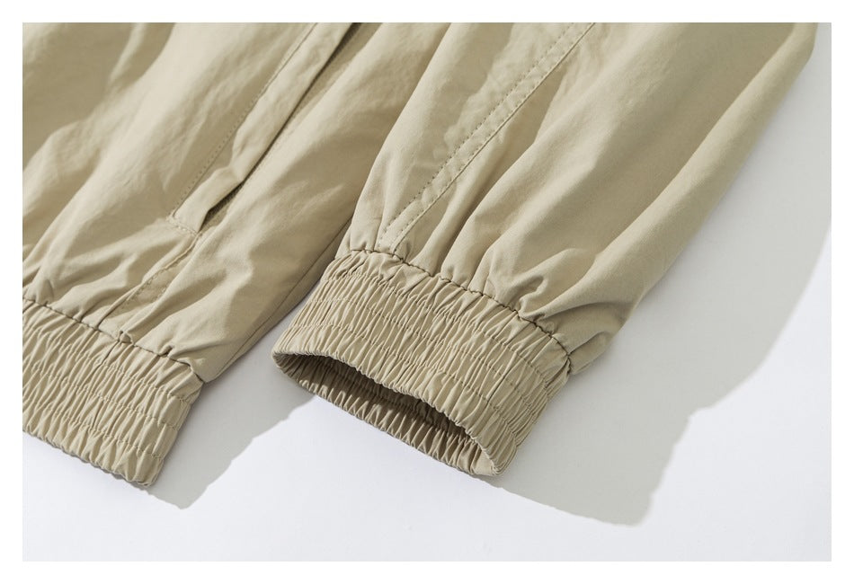 Close-up of light beige garment legs with gathered elastic cuffs and visible stitching.