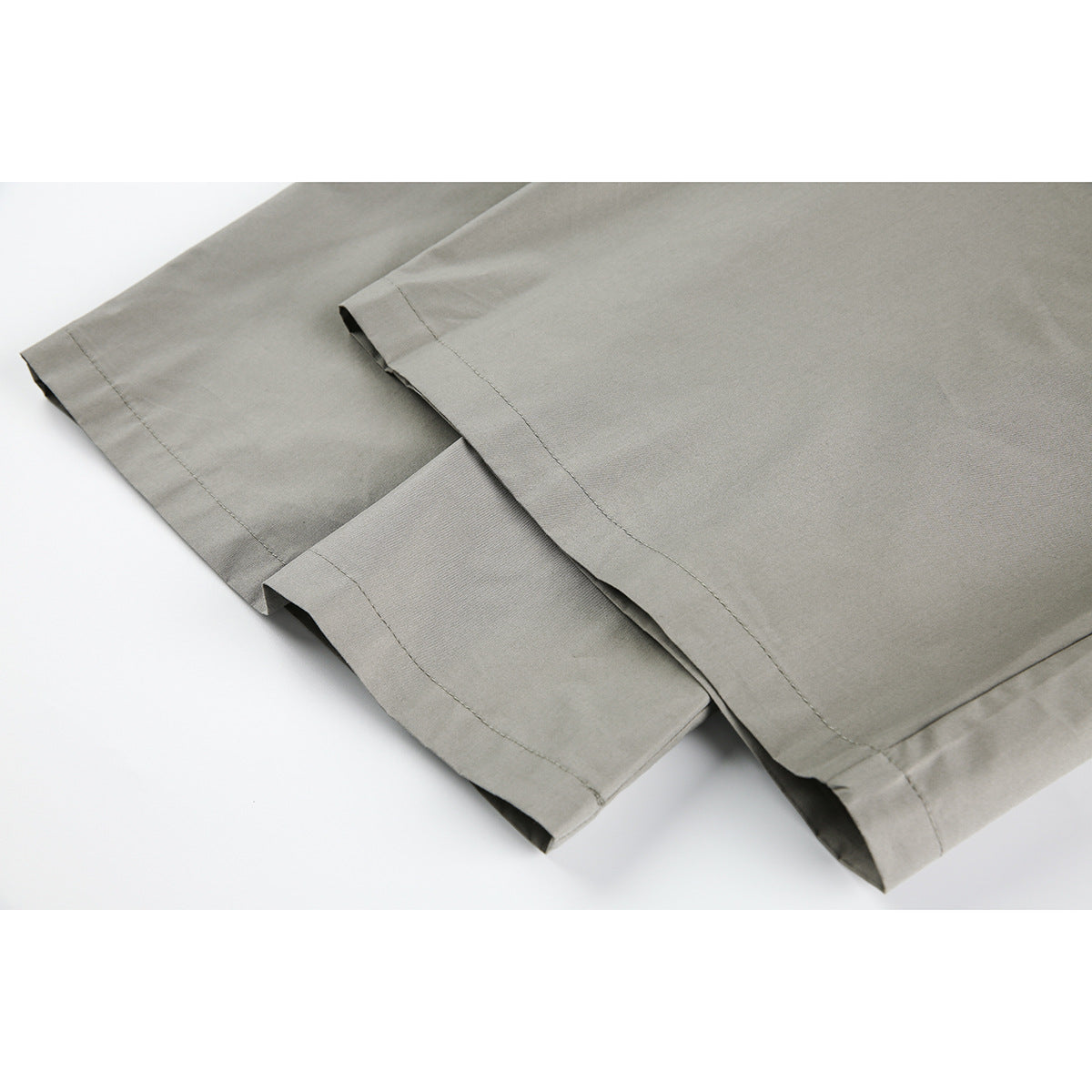 Close-up of gray trouser legs showing the stitched hems and fabric.