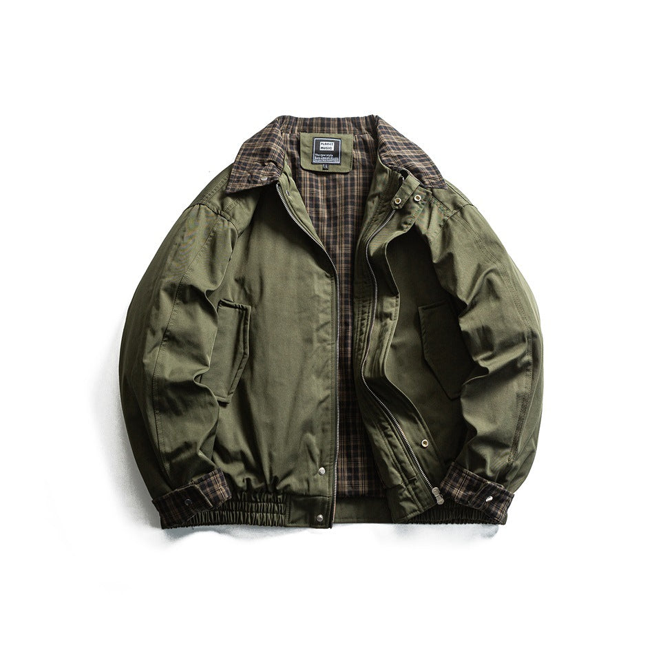 Green jacket with front zip open showing plaid lining, plaid collar, cuff trim and snap details, flat lay