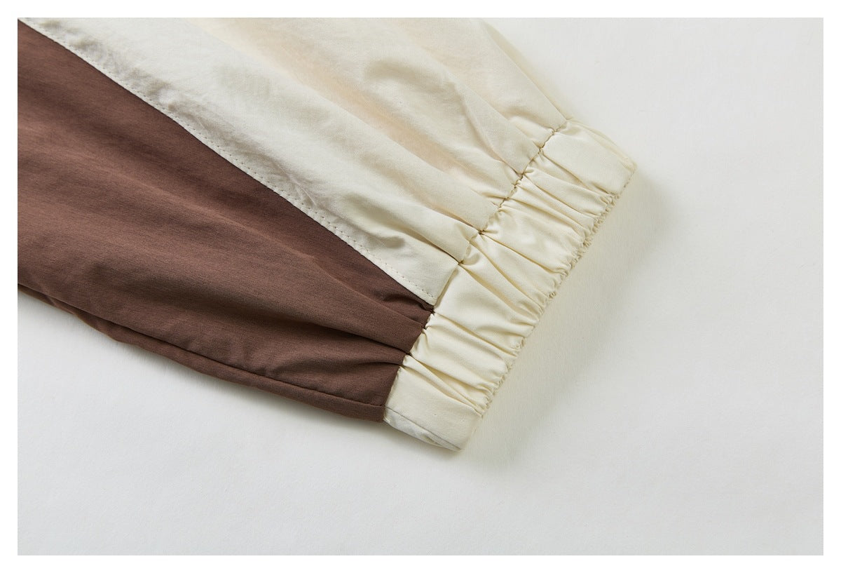 Close-up of a cream and brown sleeve ending in a gathered elastic cuff.