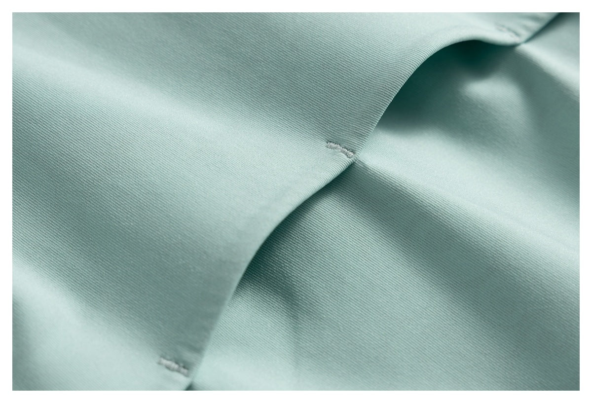 Close-up of mint fabric seams with two small reinforced openings.