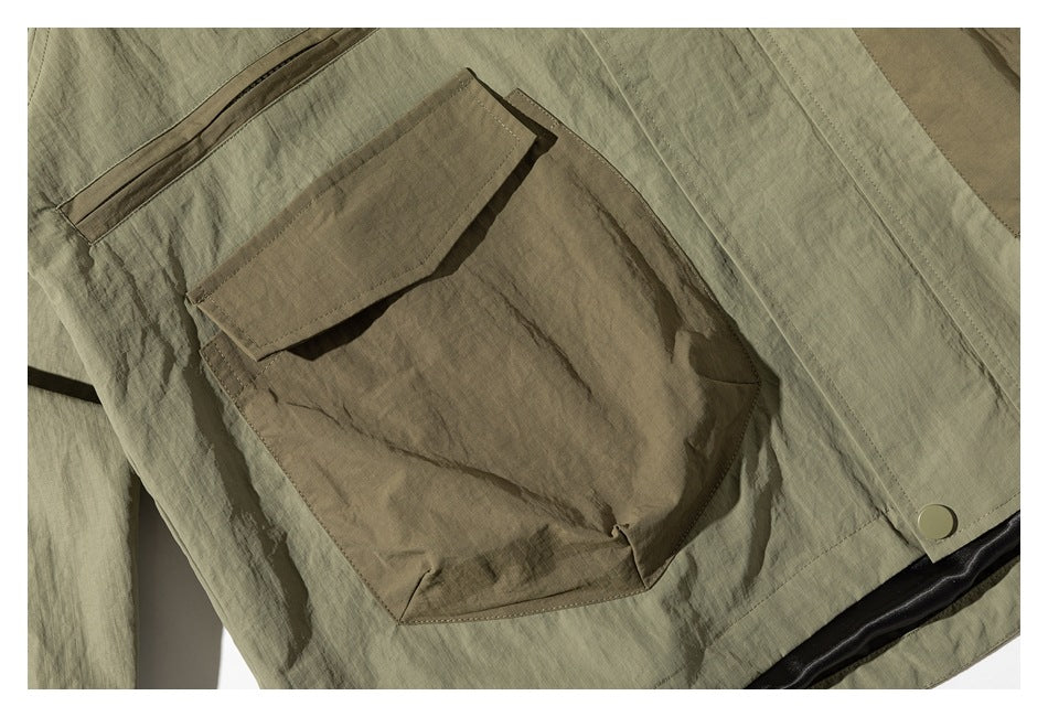 Close-up of a large brown flap pocket on an olive-green jacket.