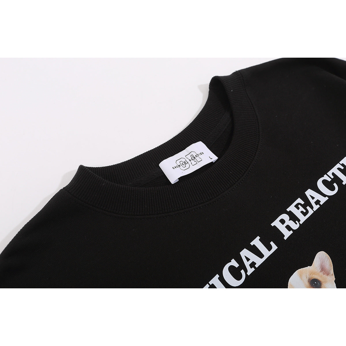 Close-up of a black sweatshirt neckline and label, with part of its white dog graphic and lettering visible.