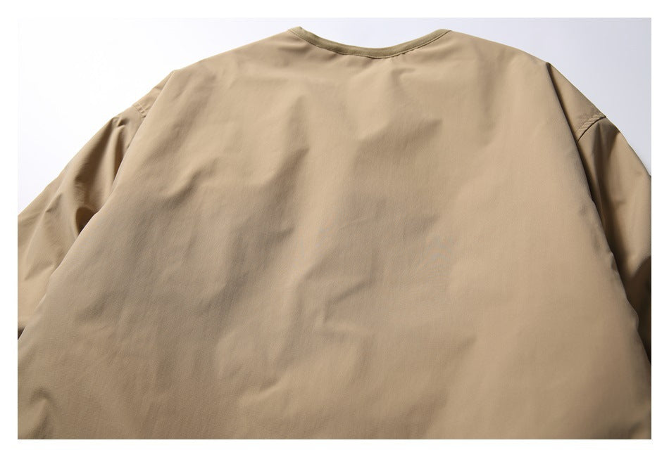 Back view of a plain tan long-sleeved garment with a rounded neckline and darker trim.