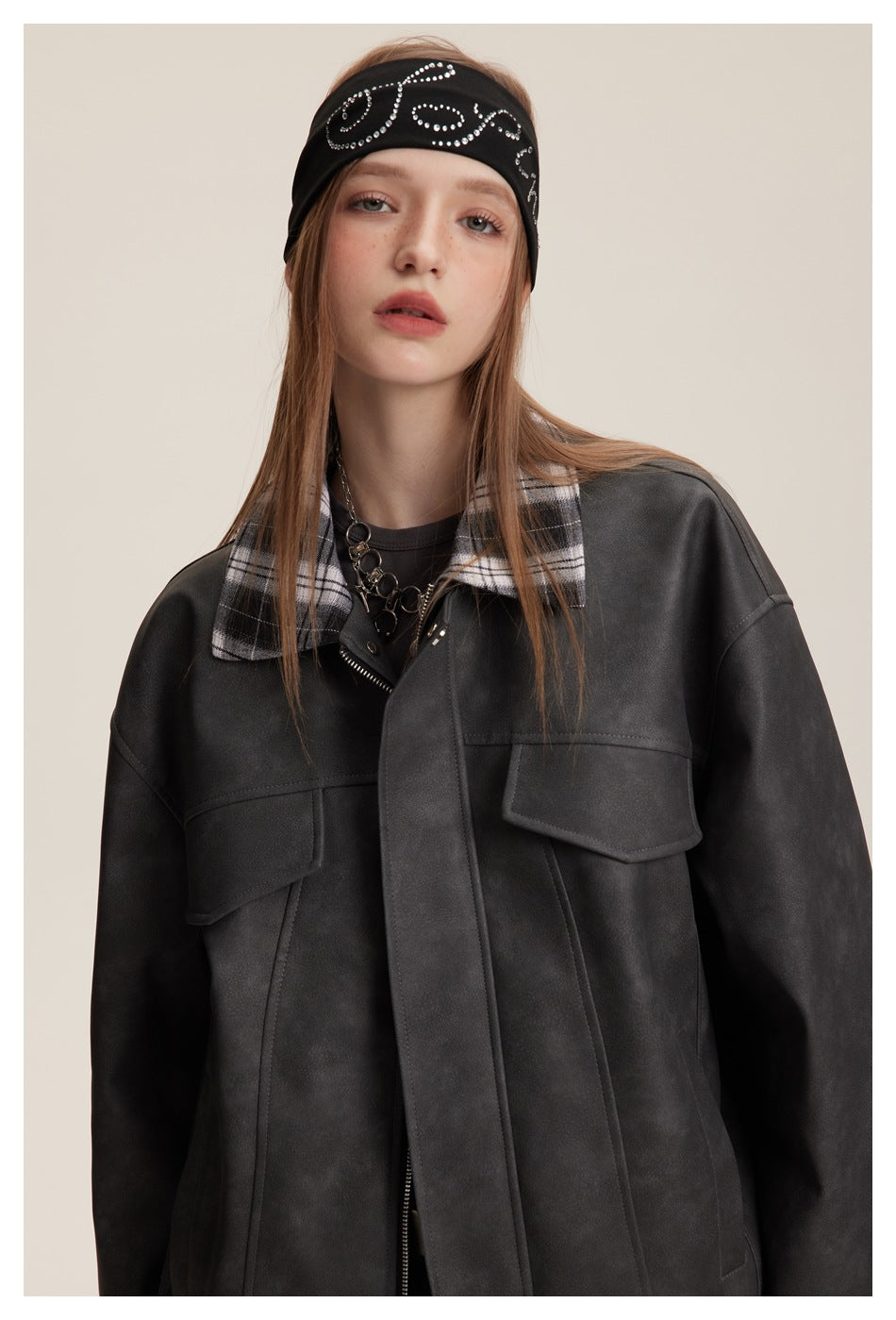 Close view of a model in a charcoal jacket with a black-and-white plaid collar and two flap chest pockets.