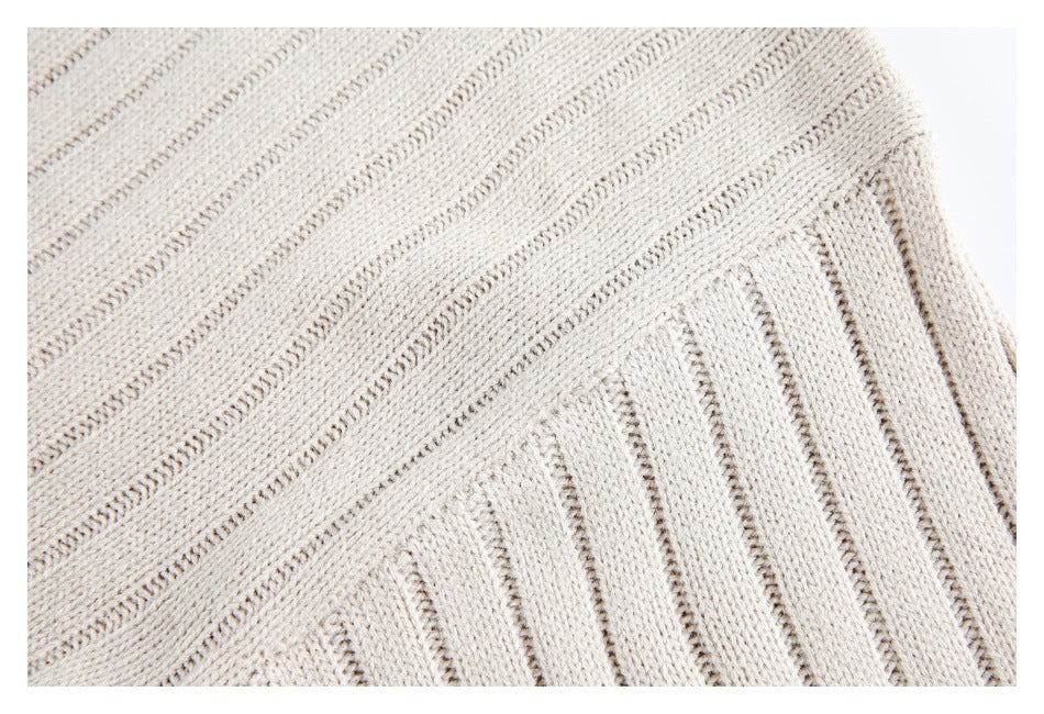 Close-up of a seam joining sections of the cream rib-knit garment.