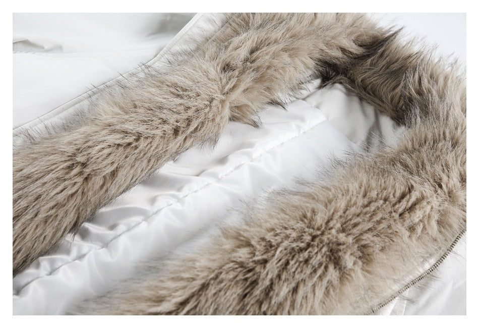 Close-up of beige faux-fur trim arranged over a white quilted garment.