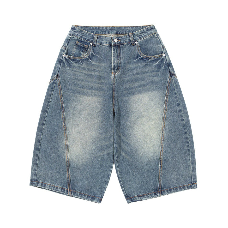 Front view of washed blue knee-length wide-leg denim shorts with faded thighs, whiskering and curved leg seams