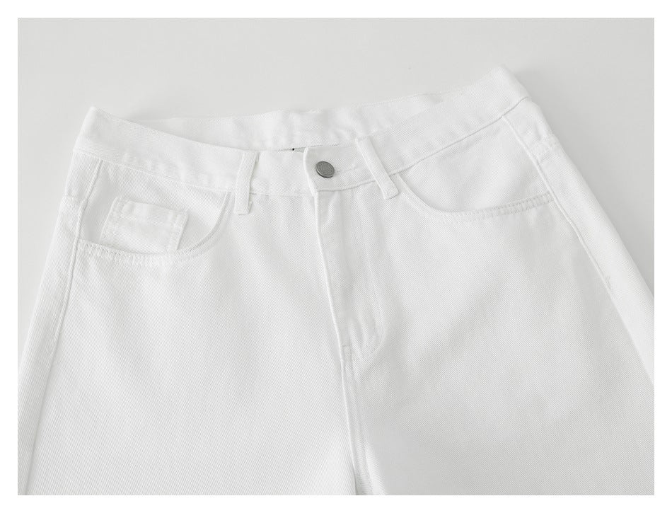 Close-up front view of white pants showing the waistband, button, belt loops, and front pockets.