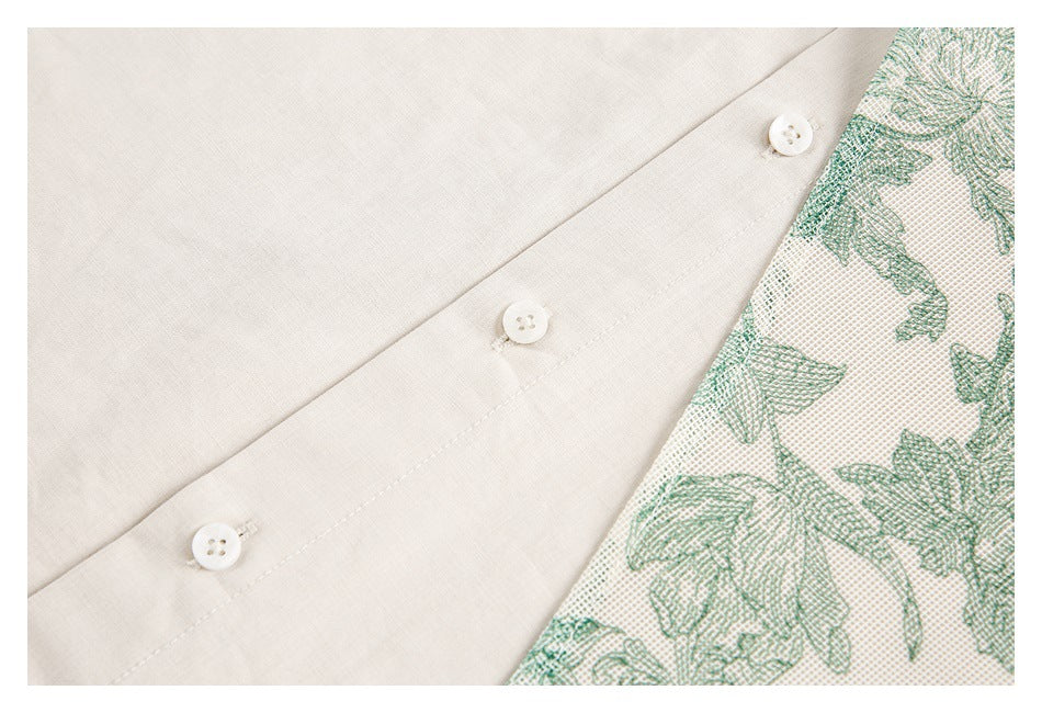 Close-up of three white buttons beside a green floral-patterned panel on cream fabric.