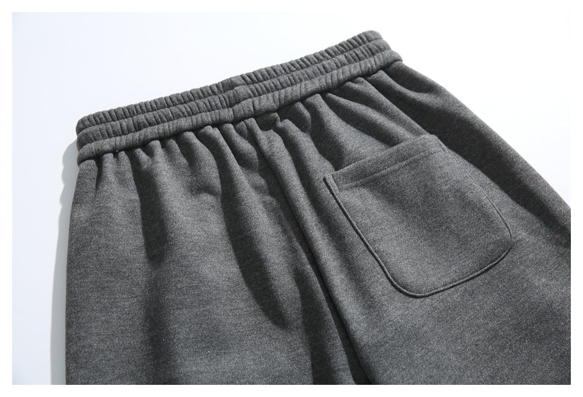 Close-up of charcoal gray pants with a gathered elastic waistband and a large patch pocket.