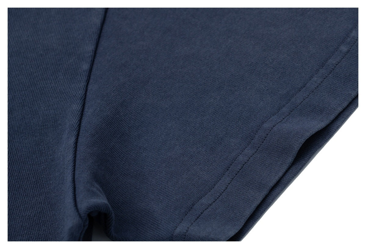 Close-up of a stitched hem on dark navy fabric.
