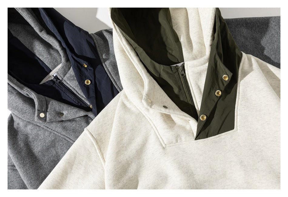 Several hooded pullover jackets in cream, charcoal gray, and navy, shown with contrasting inner plackets.