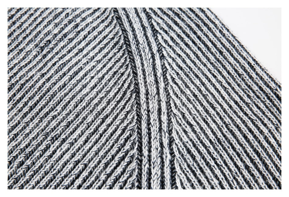 Close-up of the rib-knit raglan shoulder seam on a gray marled sweater.