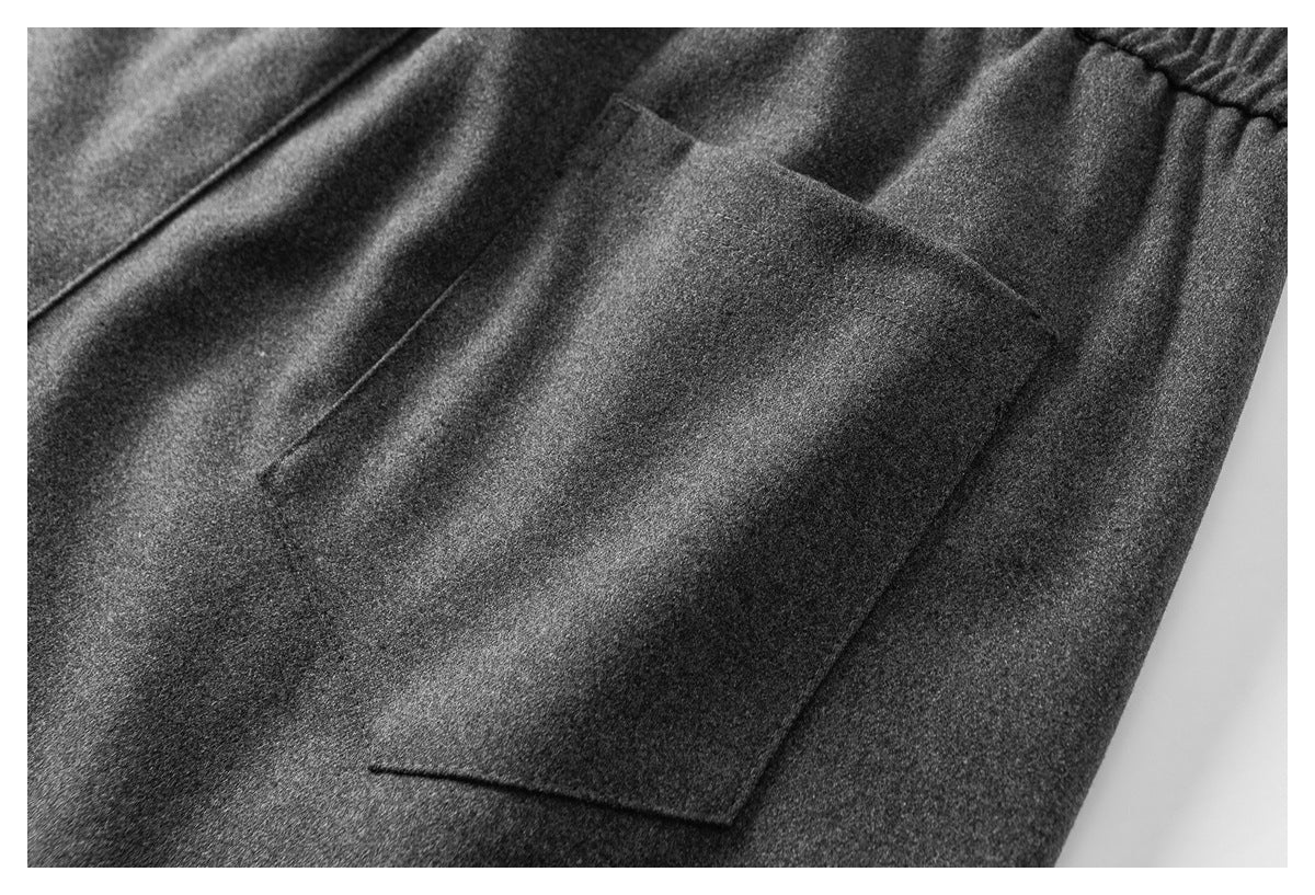 Close-up of a rectangular pocket on charcoal-gray pants.