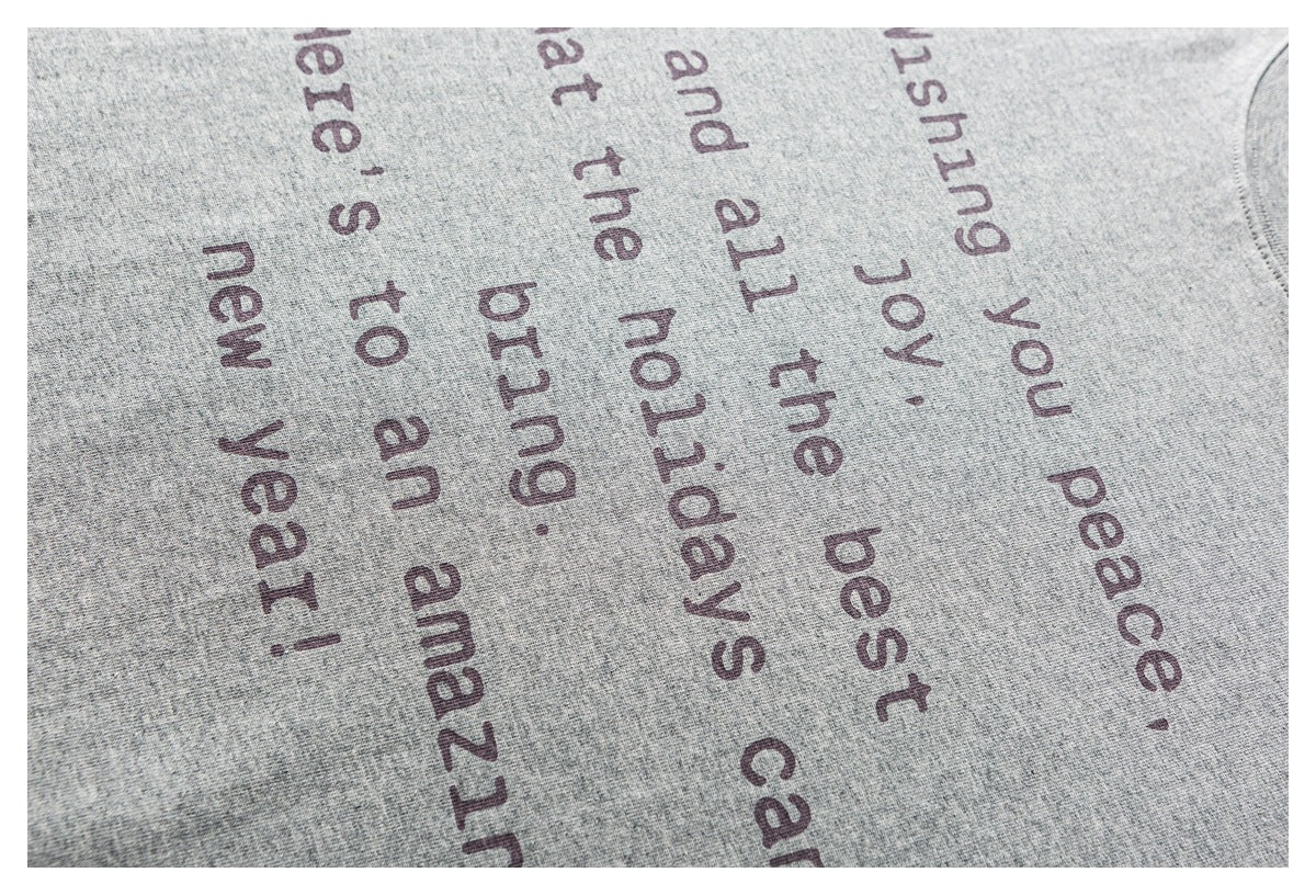 Close-up of a heather gray shirt with dark English text printed across the fabric.