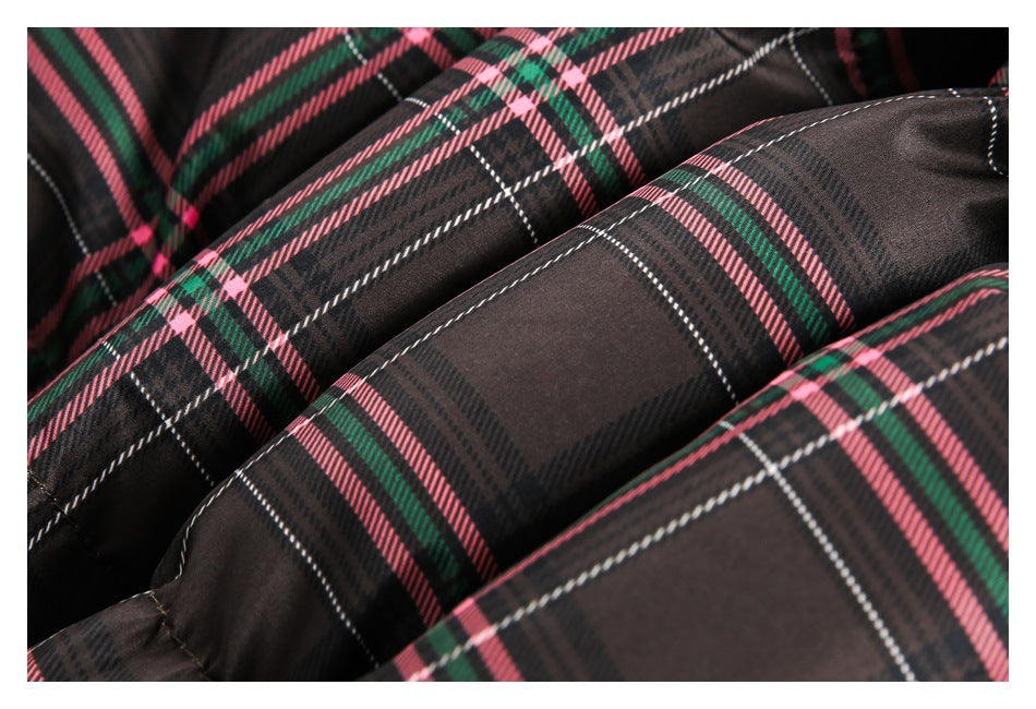 Close-up of stitched, padded sections in dark plaid with pink, green, and white stripes.