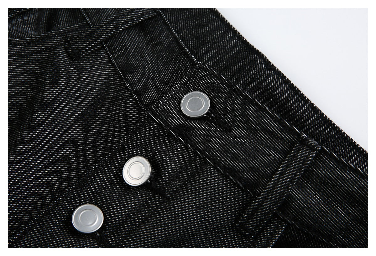 Close-up of black jeans showing silver fly buttons, buttonholes and stitched waistband details.