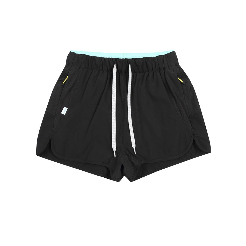 Black shorts with white drawstring, aqua inner waistband and yellow zipper pulls, flat lay