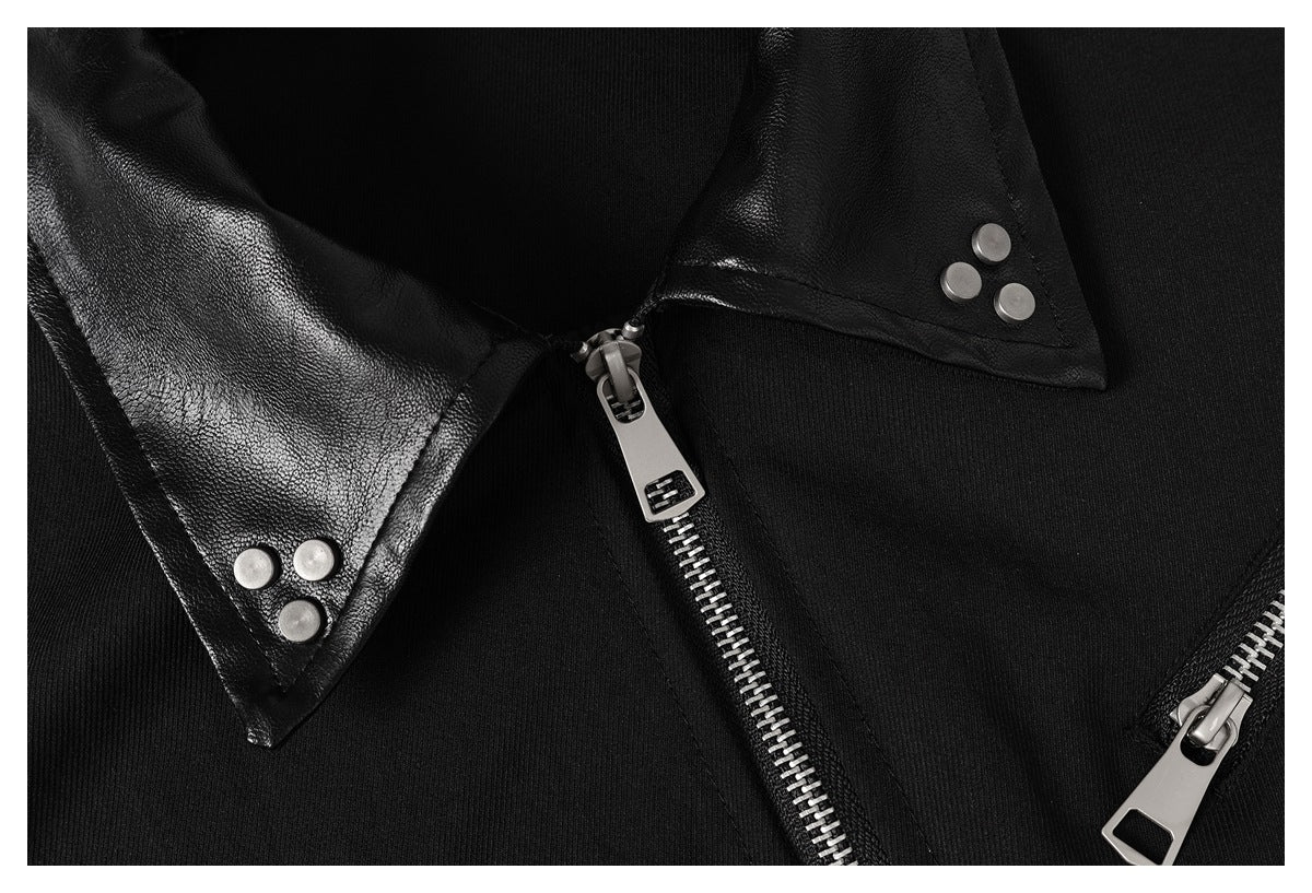 Tight close-up of the black jacket’s glossy pointed collar, silver snaps, and metal front zippers.
