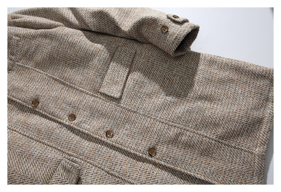 Close-up of the beige herringbone coat's front buttons, chest pocket, and sleeve cuff.