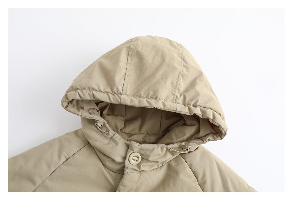 Close-up of the beige jacket’s hood and neckline, with drawcord toggles and a front button.
