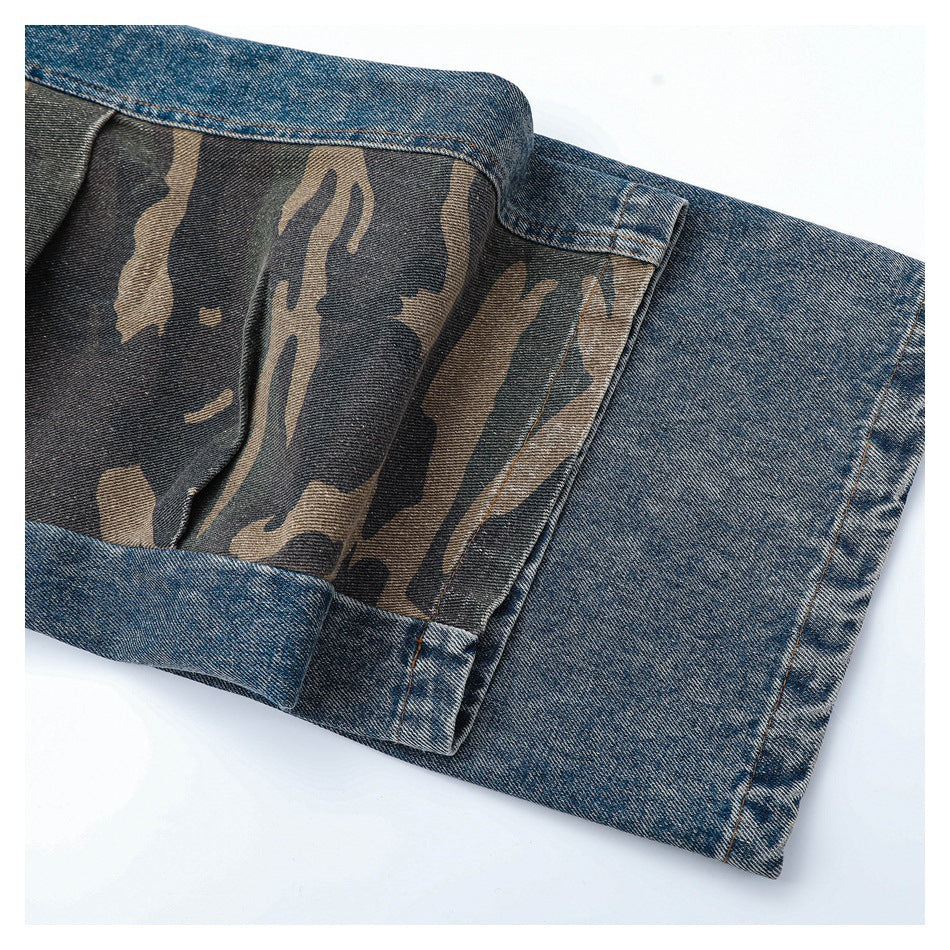 Close-up of a blue denim garment with a brown, black, and olive camouflage inner panel.