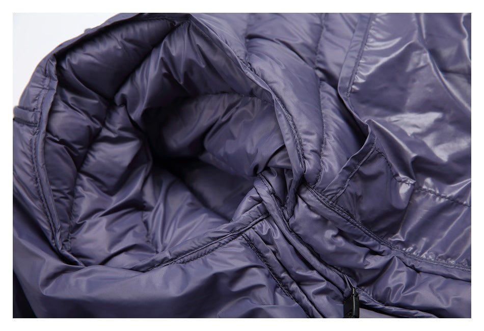 Close-up of the open hood and stitched interior construction of a shiny lavender-gray garment.