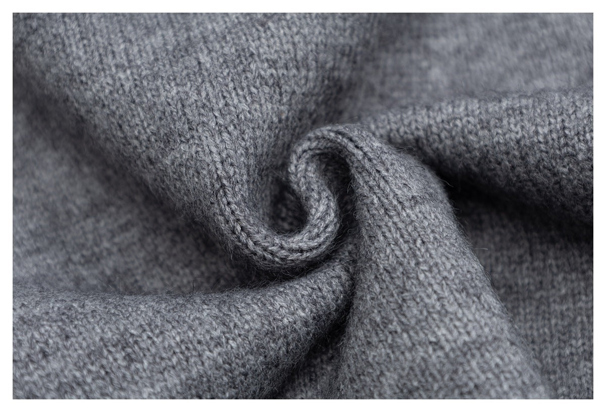 Close-up of gray knitted fabric folded to show its soft-looking stitch texture.