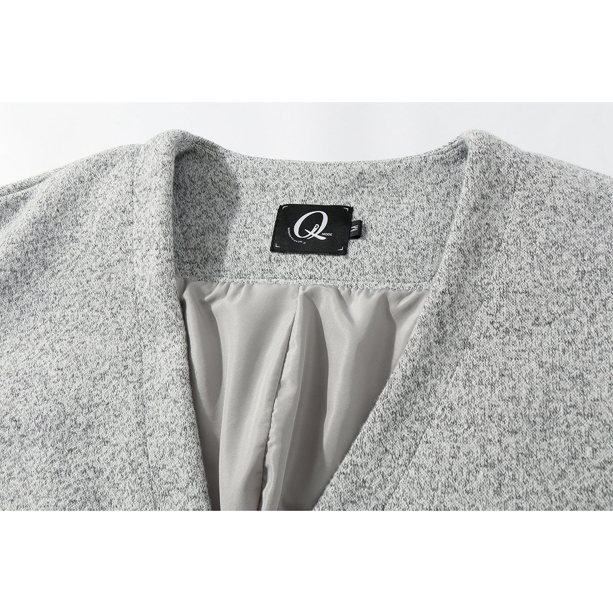 Close-up of a gray marled knit garment's open neckline, pale lining, and black Q Mode label.