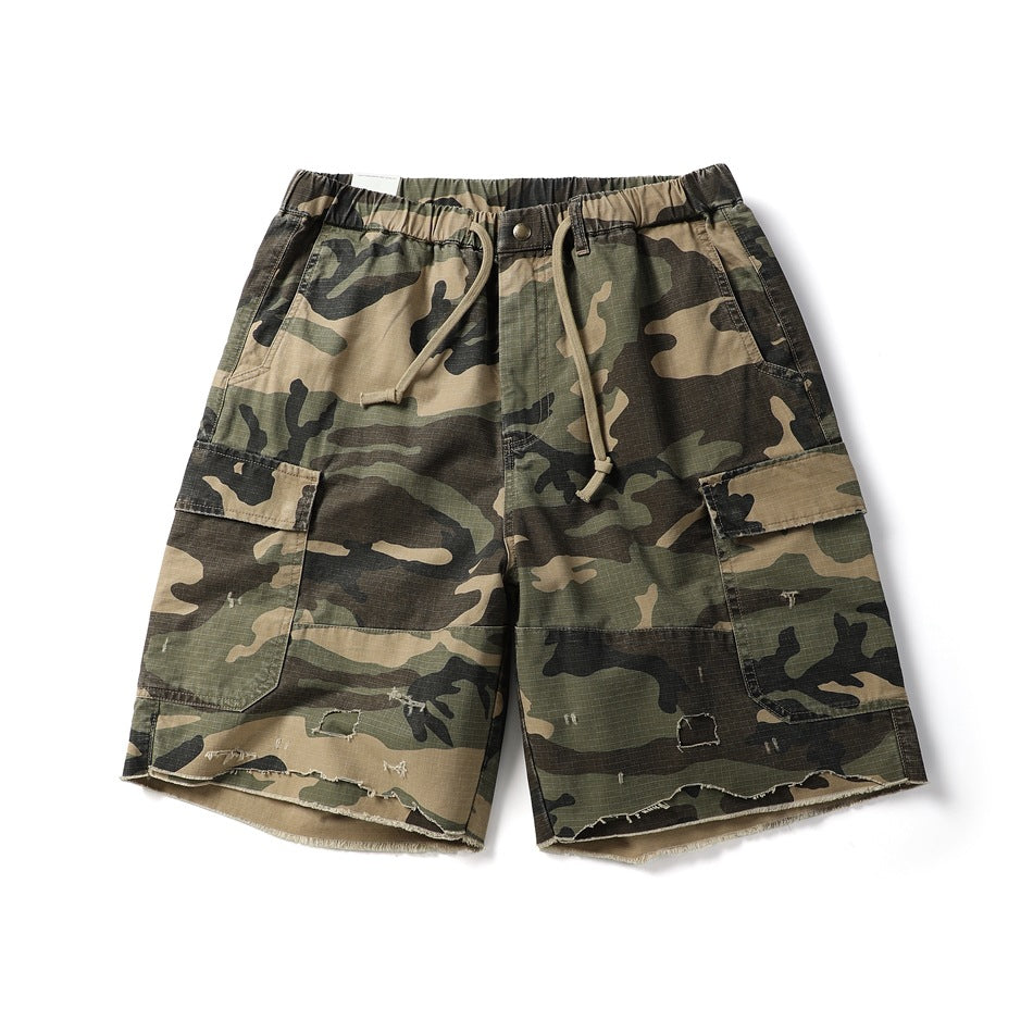 Camouflage cargo shorts flat lay with drawstring waist, flap pockets and distressed frayed raw hem