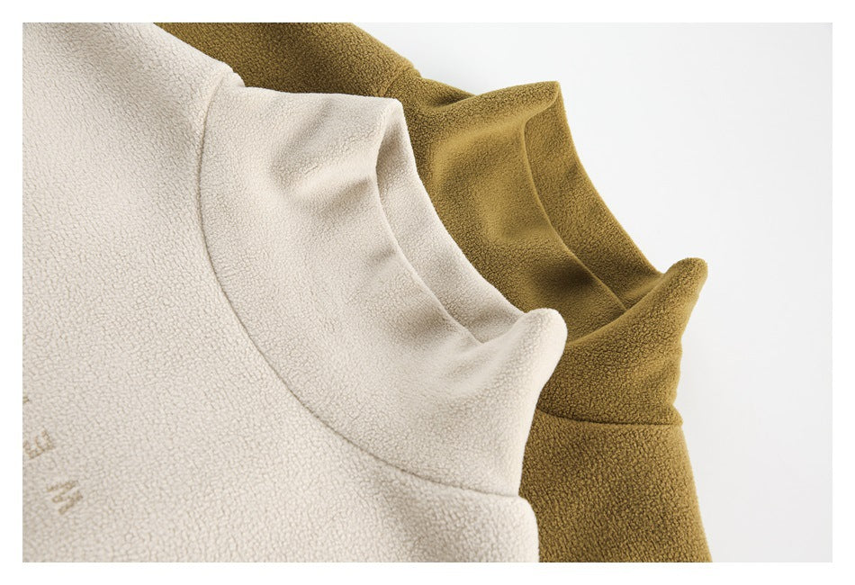 Close-up of the raised collars and textured fabric of cream and mustard high-neck tops.