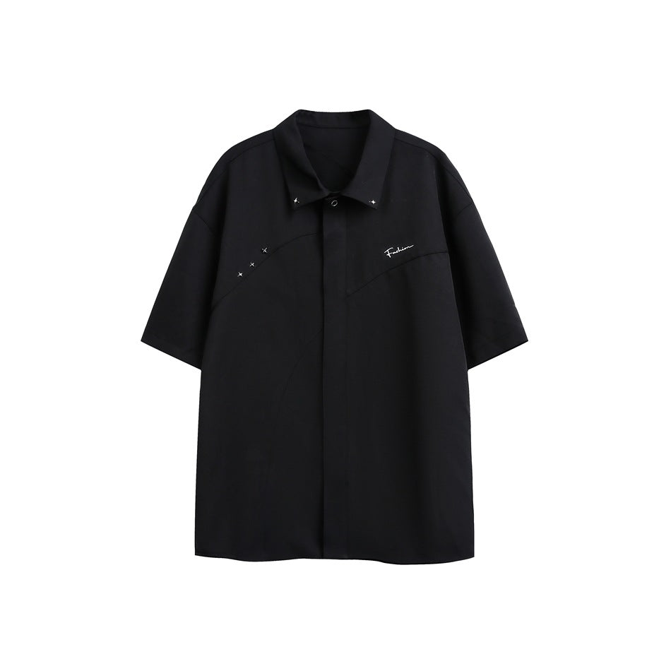 Black short-sleeve collared shirt flat lay with curved seams, star studs on the collar and shoulder, and chest embroidery