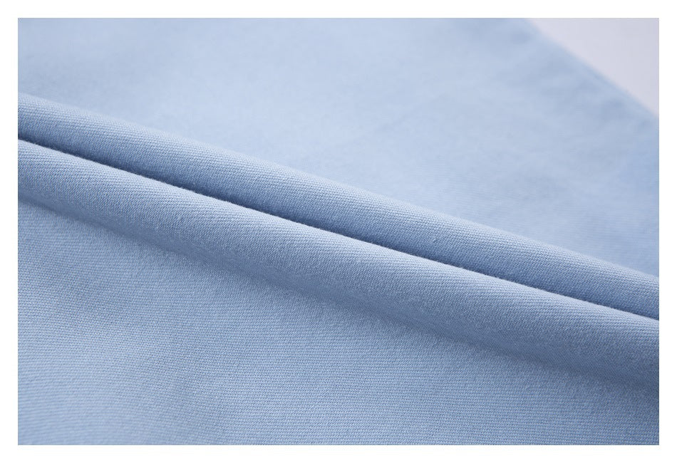 Close-up of light blue shirt fabric folded to show its texture.
