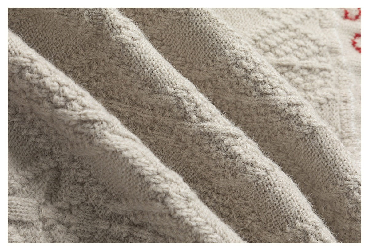 Macro view of the cream sweater's thick knit texture and raised seams.
