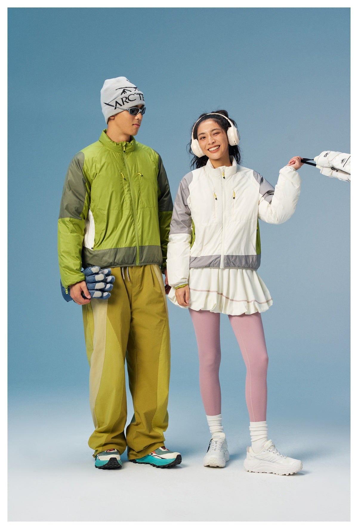 Two models wear lime green and white colorways of a zip jacket, both with contrasting gray panels.