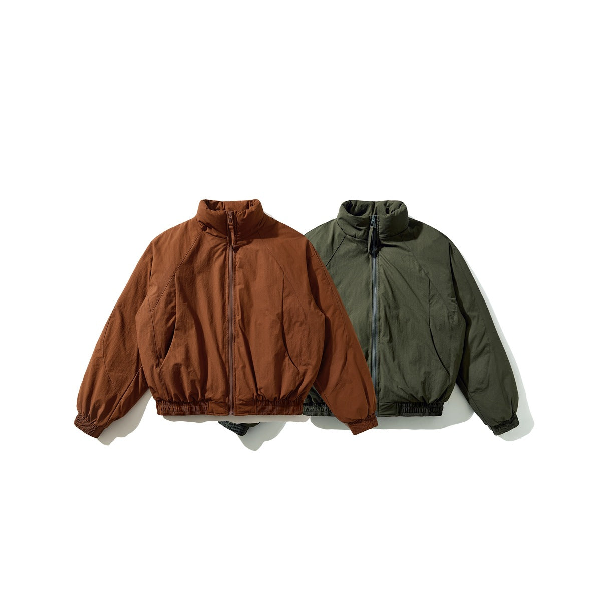 Two cropped zip jackets with high collars, one rust brown and one dark olive green, shown from the front.
